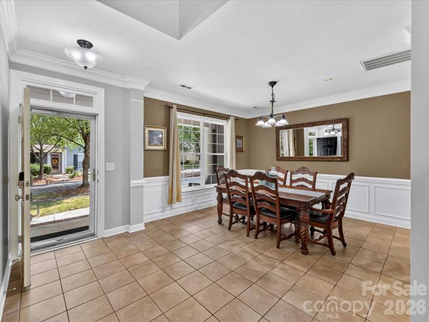 18625 The Commons Boulevard, Cornelius, NC 28031.  MLS# CAR4397710, YatesRealty ID 36310. The elegant formal Dining Room features classic wainscoting, crown molding, abundant natural light, and generous space for hosting family gatherings and special occasions.