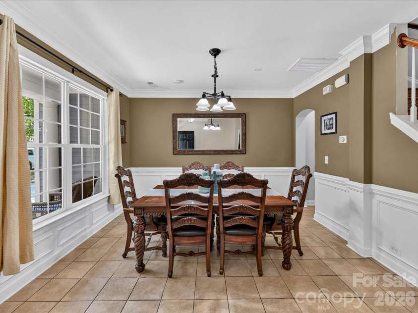 18625 The Commons Boulevard, Cornelius, NC 28031.  MLS# CAR4397710, YatesRealty ID 36310. The elegant formal Dining Room features classic wainscoting, crown molding, abundant natural light, and generous space for hosting family gatherings and special occasions.
