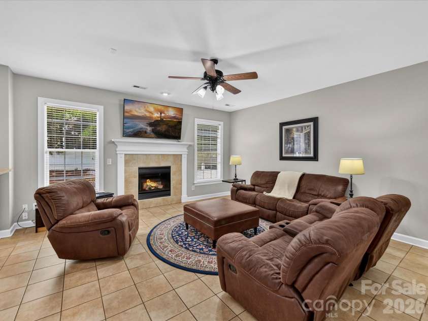 18625 The Commons Boulevard, Cornelius, NC 28031.  MLS# CAR4397710, YatesRealty ID 36310. The spacious Great Room features an inviting fireplace, abundant natural light, and an open-concept layout that seamlessly connects to the kitchen, creating the perfect space for everyday living and entertainin