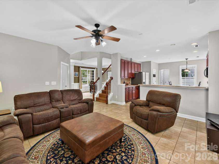 18625 The Commons Boulevard, Cornelius, NC 28031.  MLS# CAR4397710, YatesRealty ID 36310. The spacious Great Room features an inviting fireplace, abundant natural light, and an open-concept layout that seamlessly connects to the kitchen, creating the perfect space for everyday living and entertainin