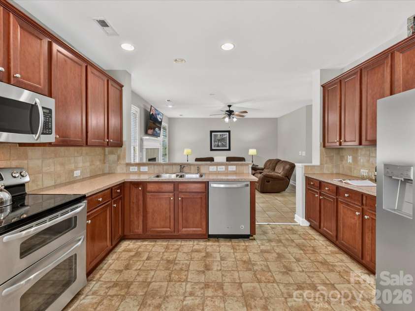 18625 The Commons Boulevard, Cornelius, NC 28031.  MLS# CAR4397710, YatesRealty ID 36310. The spacious kitchen features abundant cabinetry, generous counter space, stainless steel appliances, a convenient breakfast bar, and an open layout overlooking the Great Room for effortless everyday living and
