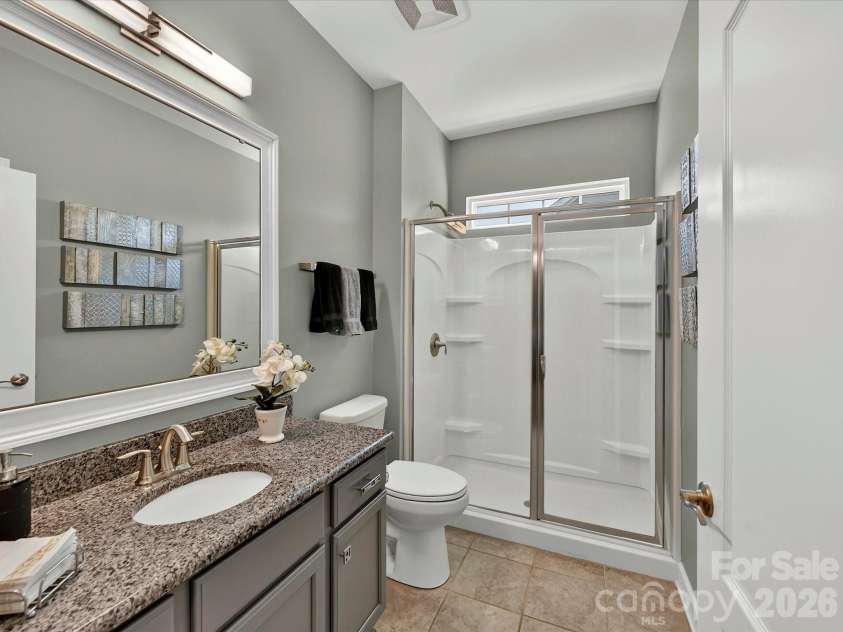 3029 Oliver Stanley Trail, Lancaster, SC 29720.  MLS# CAR4400413, YatesRealty ID 36334. Full Guest Bath on Main with Granite Counters, Framed Mirror, Linen Closet and Tiled Flooring. Upgraded Light Fixture