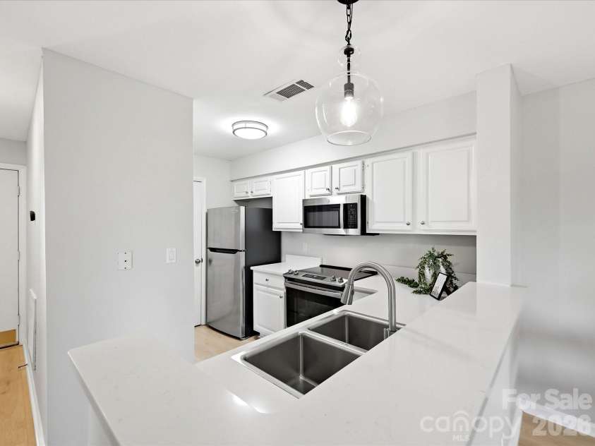 18817 Nautical Drive, Cornelius, NC 28031.  MLS# CAR4402738, YatesRealty ID 36724. The bright, open kitchen features quartz counters, stainless steel appliances, ample cabinetry, and seamless flow into the main living area.