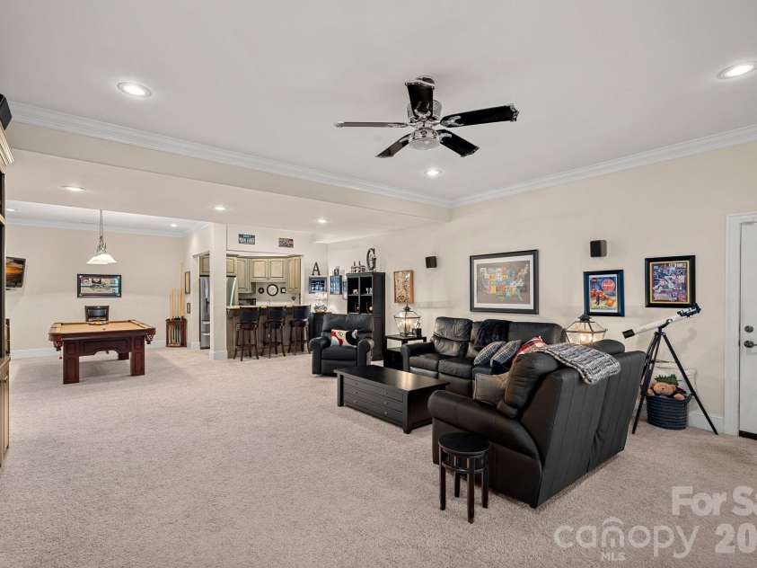 8056 Windsong Road, Denver, NC 28037.  MLS# CAR4338540, YatesRealty ID 3683. Basement/lower level family room with kitchenette and billiard table; access to second garage featuring a workshop area with built-ins, gym, and utility storage.