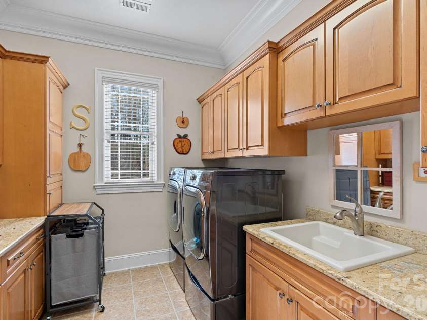 8056 Windsong Road, Denver, NC 28037.  MLS# CAR4338540, YatesRealty ID 3683. Large laundry room with sink, just off the kitchen and adjacent to the garage entry.