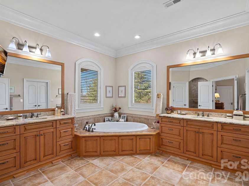 8056 Windsong Road, Denver, NC 28037.  MLS# CAR4338540, YatesRealty ID 3683. Primary en-suite with dual vanities, jetted tub, large walk-in shower, and walk-in closet.