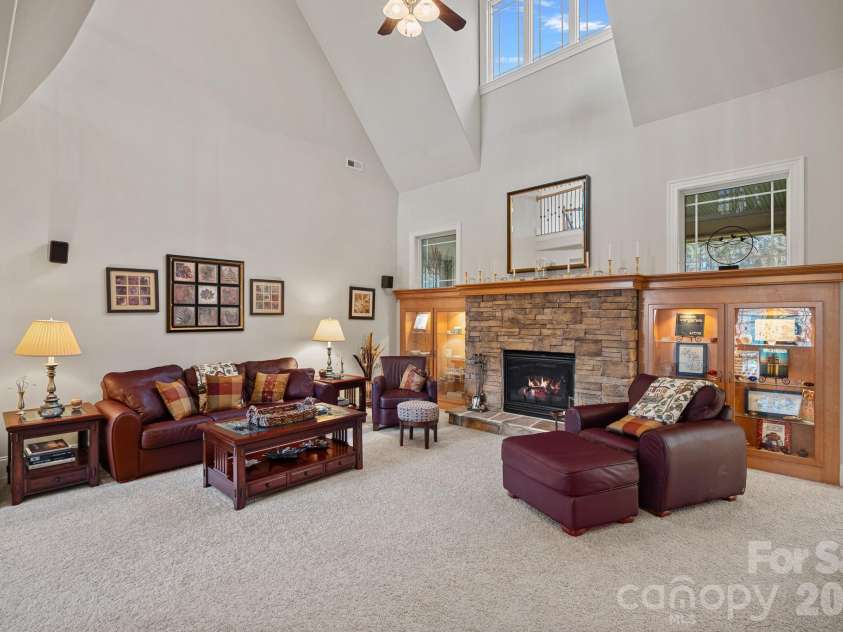 8056 Windsong Road, Denver, NC 28037.  MLS# CAR4338540, YatesRealty ID 3683. Spacious living room with vaulted ceilings, stone fireplace, and custom built-ins.
