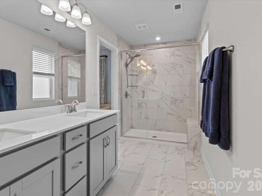 8122 Downy Oak Lane, Charlotte, NC 28269.  MLS# CAR4394900, YatesRealty ID 36945. Beautiful tiled shower in Primary Bathroom