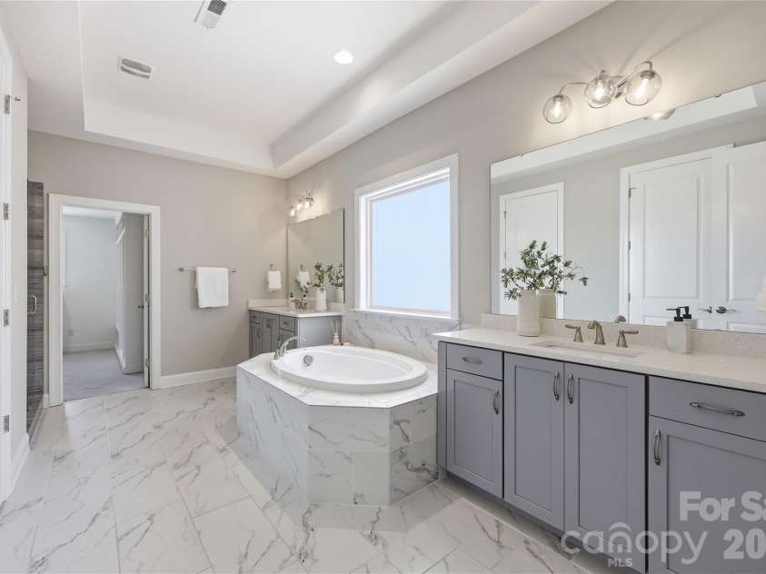 18314 Doves Crest Road, Cornelius, NC 28031.  MLS# CAR4397375, YatesRealty ID 36956. Primary bathroom offers separate sink vanities separated by a generously sized soaking tub