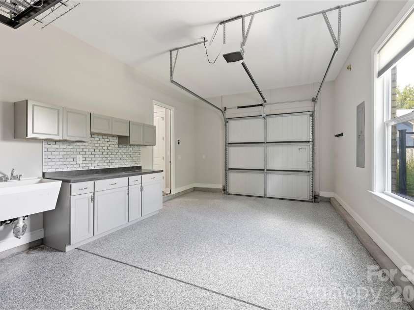 18314 Doves Crest Road, Cornelius, NC 28031.  MLS# CAR4397375, YatesRealty ID 36956. Third bay garage with utility sink, custom cabinetry storage, and epoxy floors
