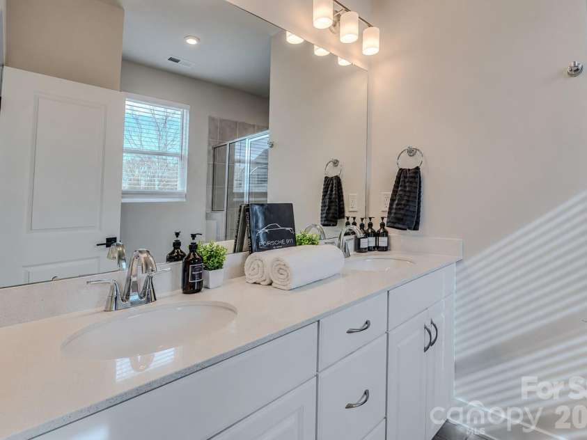 3023 Jolene Court, Charlotte, NC 28206.  MLS# CAR4399179, YatesRealty ID 36983. The bright and modern primary  bathroom features a spacious vanity with ample counter space and a walk-in shower, offering both style and everyday functionality.