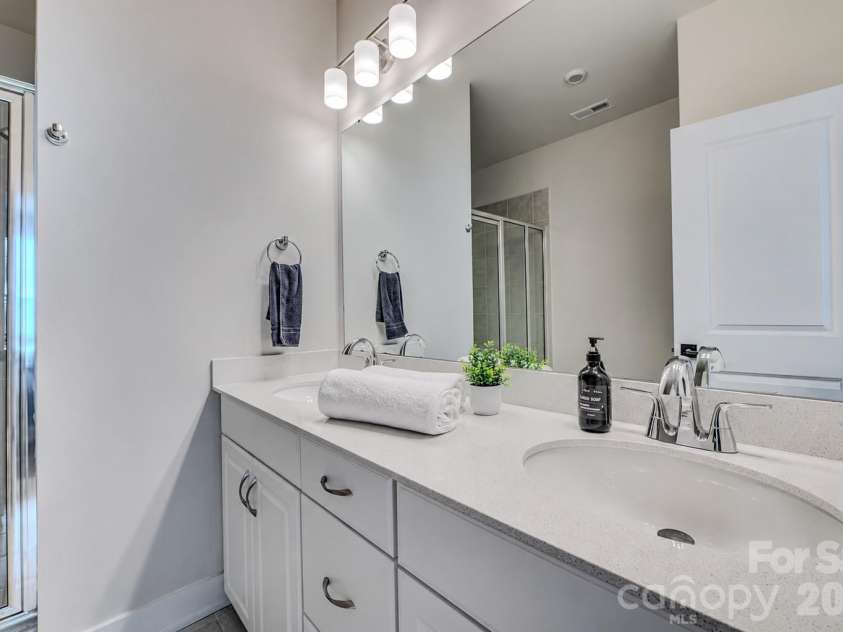 3019 Jolene Court, Charlotte, NC 28206.  MLS# CAR4399234, YatesRealty ID 36984. The spacious primary bathroom features a dual-sink vanity with ample counter space, modern finishes, and a large walk-in shower, creating a bright and relaxing retreat.