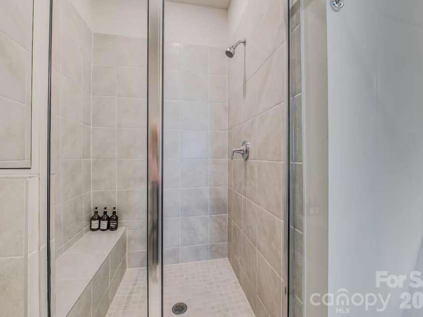 3019 Jolene Court, Charlotte, NC 28206.  MLS# CAR4399234, YatesRealty ID 36984. The spacious primary bathroom features a dual-sink vanity with ample counter space, modern finishes, and a large walk-in shower, creating a bright and relaxing retreat.