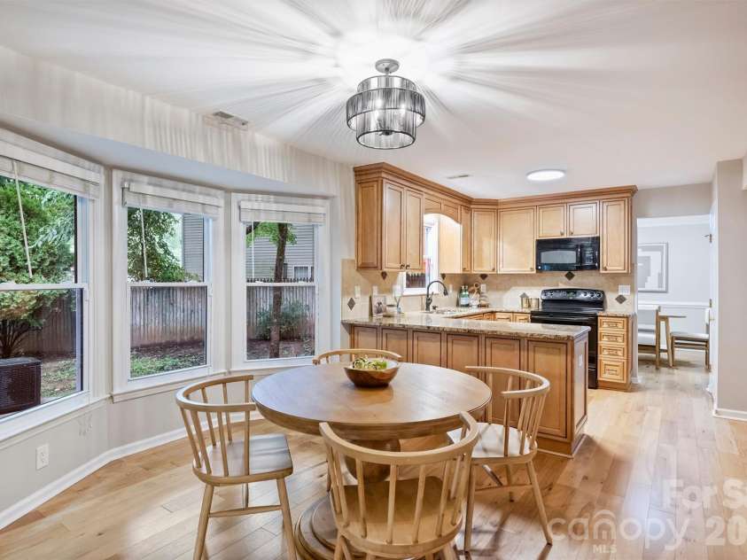 2500 Crescent Knoll Drive, Matthews, NC 28105.  MLS# CAR4399861, YatesRealty ID 37086. Kitchen is complete with granite countertops, a tile backsplash, generous breakfast bar, and sunny bay-window breakfast nook.