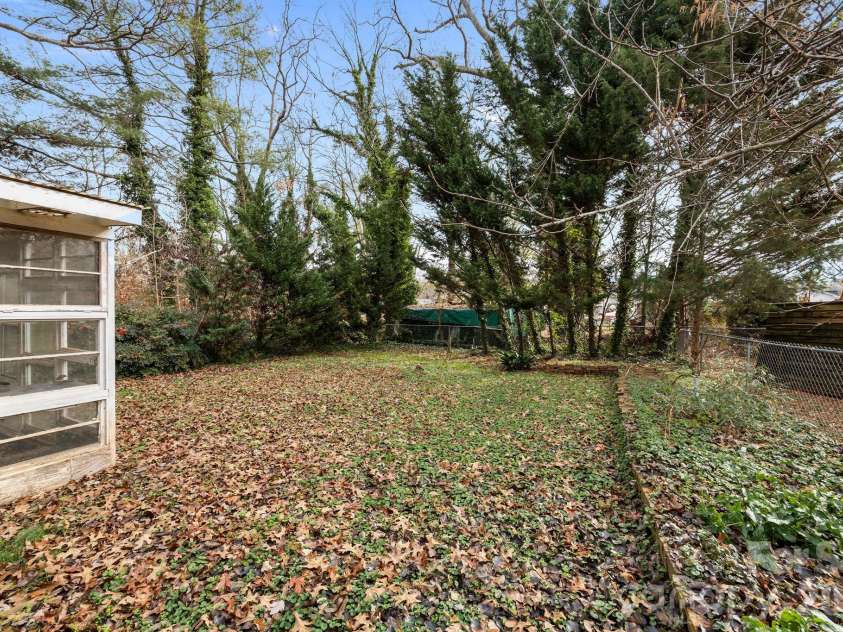 1223 Lafayette Street, Shelby, NC 28152.  MLS# CAR4373858, YatesRealty ID 3727. Backyard extends beyond the fence,  beside the outbuilding and greenhouse.
