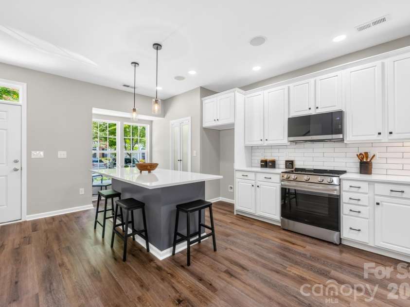143 Arcadian Way, Mooresville, NC 28117.  MLS# CAR4384675, YatesRealty ID 37401. The expansive kitchen island, featuring seating and ample storage, serves as an exceptional workspace for meal preparation, casual dining, and hosting.