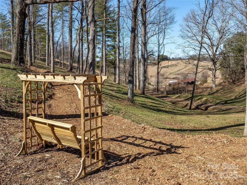 55 Plantation Drive, Asheville, NC 28806.  MLS# CAR4230730, YatesRealty ID 3745. Swinging Rocker overlooking grounds and trail area to the north.