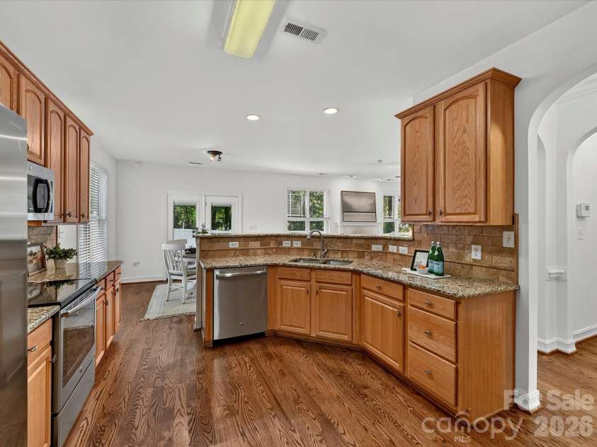 18814 Coachmans Trace, Cornelius, NC 28031.  MLS# CAR4399708, YatesRealty ID 37607. An oversized breakfast bar, granite countertops, and an open-concept design make this kitchen the heart of the home.