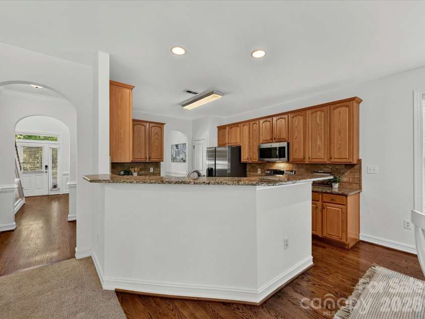 18814 Coachmans Trace, Cornelius, NC 28031.  MLS# CAR4399708, YatesRealty ID 37607. An oversized breakfast bar, granite countertops, and an open-concept design make this kitchen the heart of the home.