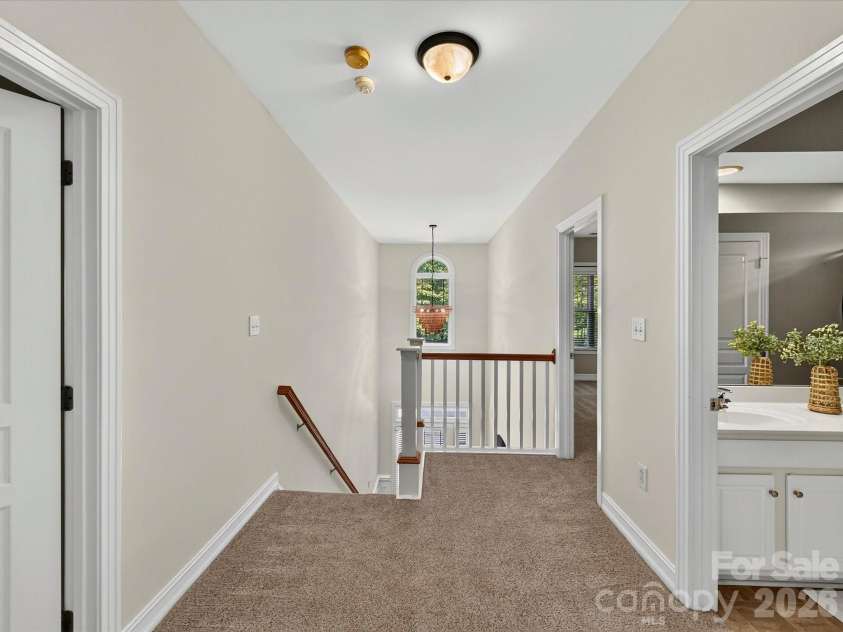 18814 Coachmans Trace, Cornelius, NC 28031.  MLS# CAR4399708, YatesRealty ID 37607. The open upper-level hallway overlooks the foyer and connects the spacious secondary bedrooms with an airy, open feel.