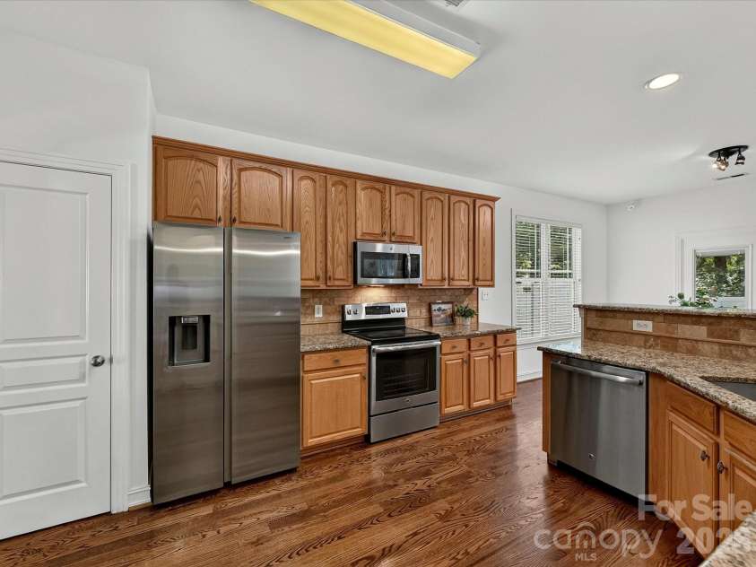 18814 Coachmans Trace, Cornelius, NC 28031.  MLS# CAR4399708, YatesRealty ID 37607. The spacious kitchen features abundant cabinetry, granite countertops, stainless steel appliances, tile back splash, pantry and a functional layout designed for everyday living and effortless entertaining.