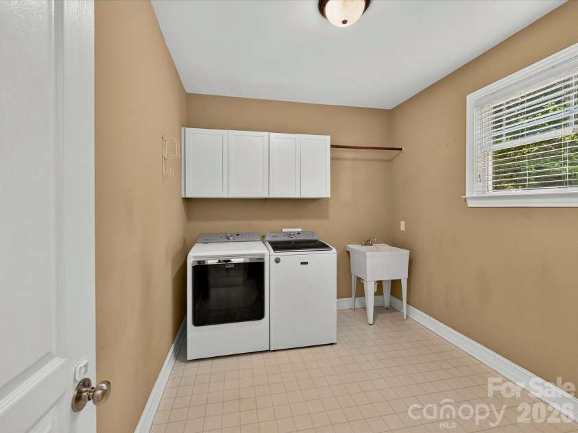 18814 Coachmans Trace, Cornelius, NC 28031.  MLS# CAR4399708, YatesRealty ID 37607. The spacious laundry room includes abundant storage cabinetry, a utility sink, and extra workspace for added everyday convenience.