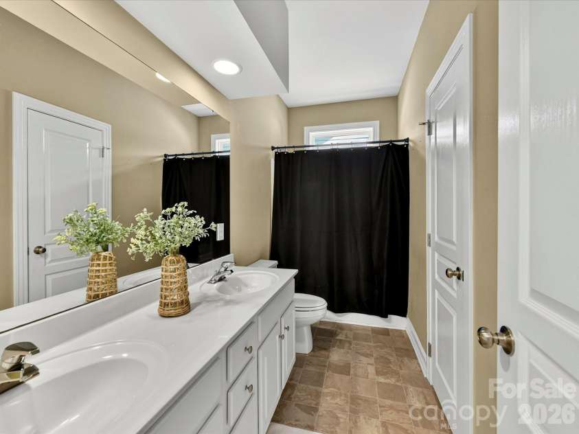 18814 Coachmans Trace, Cornelius, NC 28031.  MLS# CAR4399708, YatesRealty ID 37607. The upstairs full bath features a dual-sink vanity and a tub/shower combination, providing comfort and convenience for family or guests.