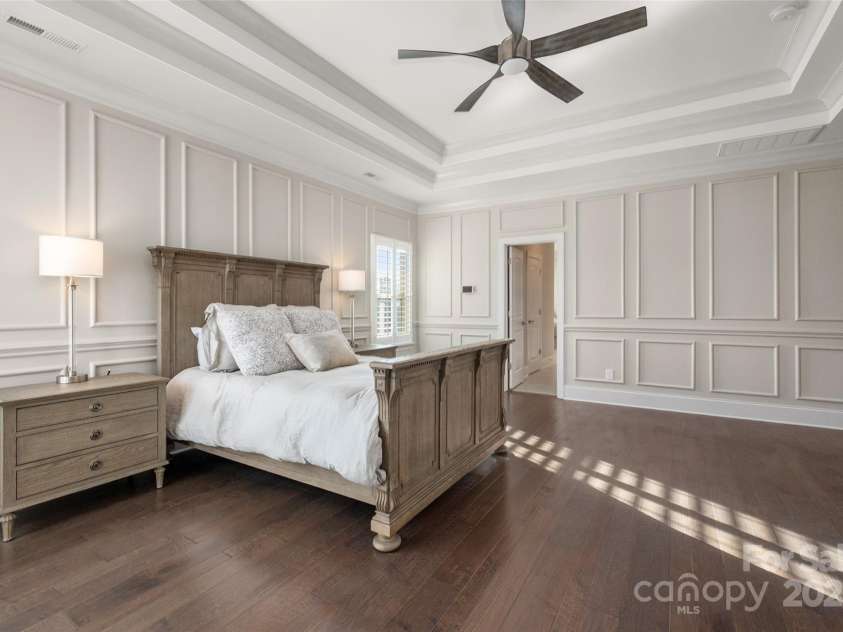 105 Downton Abbey Drive, Marvin, NC 28173.  MLS# CAR4332508, YatesRealty ID 3764. Primary bedroom with custom trim detail, hardwood flooring and multiple treyed ceiling