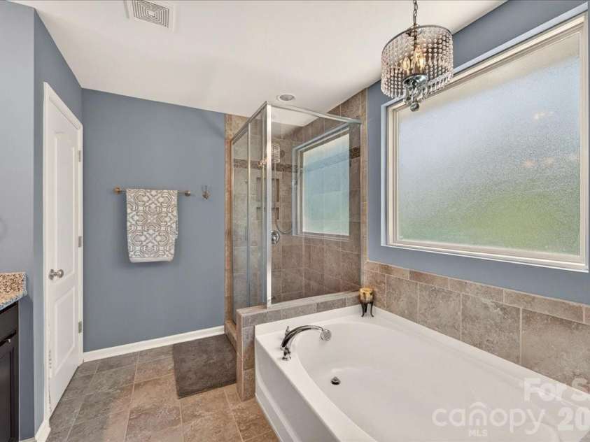 3093 Hartson Pointe Drive, Fort Mill, SC 29707.  MLS# CAR4402189, YatesRealty ID 37679. Primary bath with soaking tub and tiled shower with glass doors
