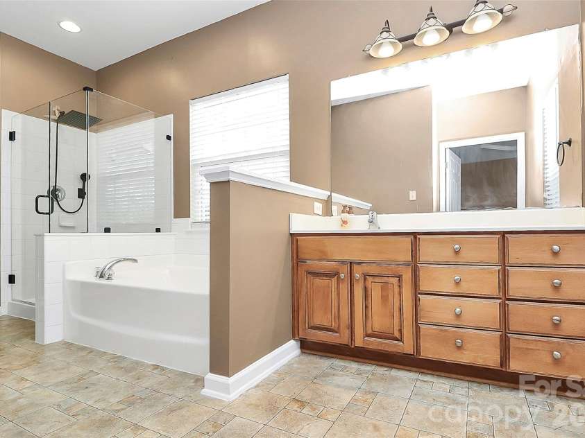 9411 Shumacher Avenue, Concord, NC 28027.  MLS# CAR4324917, YatesRealty ID 3774. Primary bathroom with frameless shower door and expansive shower head
