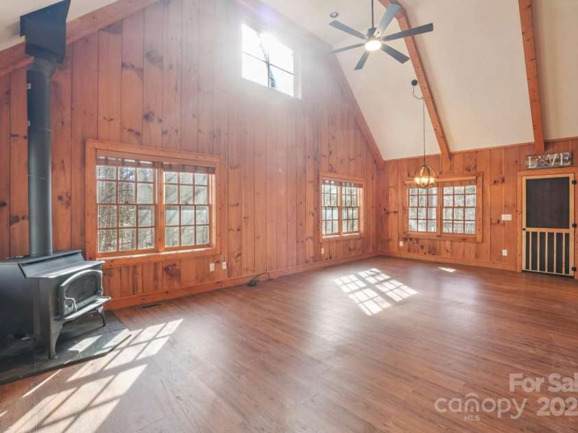 102 Knobster Way, Glenville, NC 28736.  MLS# CAR4325693, YatesRealty ID 3776. Highlighted by a wood-burning stove and vaulted ceiling.