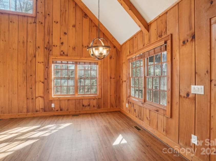 102 Knobster Way, Glenville, NC 28736.  MLS# CAR4325693, YatesRealty ID 3776. Incoming light is complemented by the richness of the wood paneling.