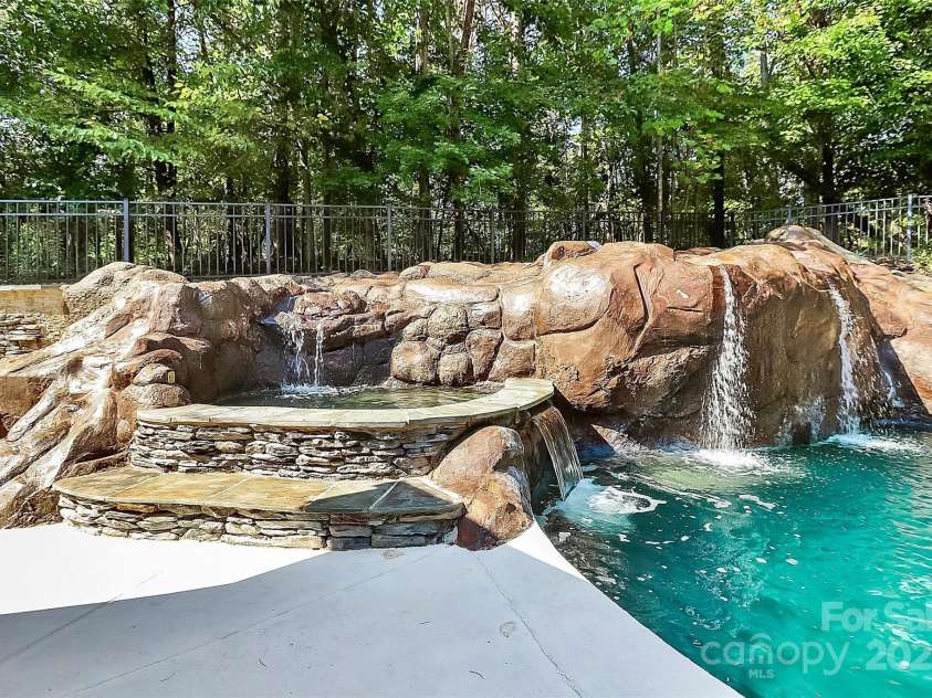 227 Wildwood Cove Drive, Mooresville, NC 28117.  MLS# CAR4214426, YatesRealty ID 3780. Hot tub, waterfalls and slide (far right). Jumping off the top of the rock is so fun!