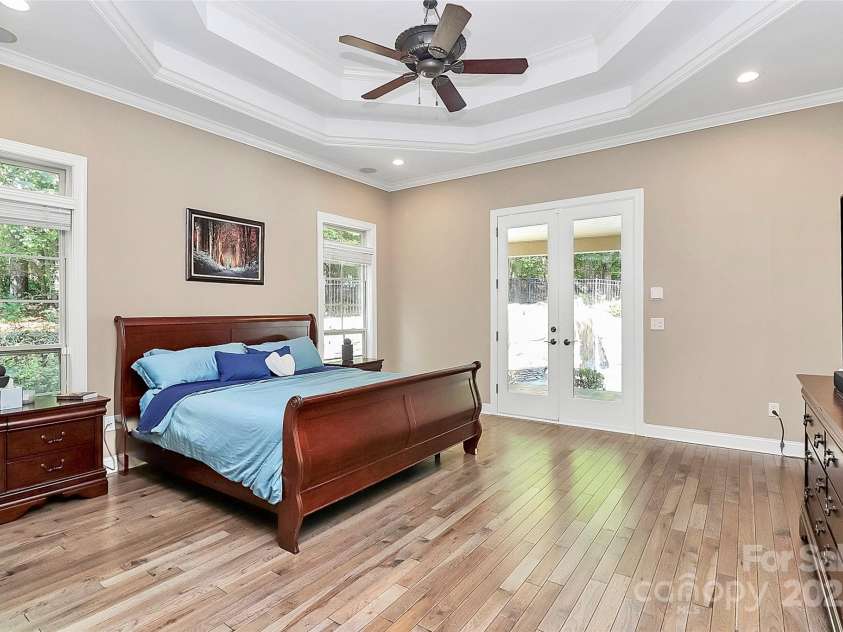 227 Wildwood Cove Drive, Mooresville, NC 28117.  MLS# CAR4214426, YatesRealty ID 3780. Spacious primary suite w/ double tray ceiling and access to back porch