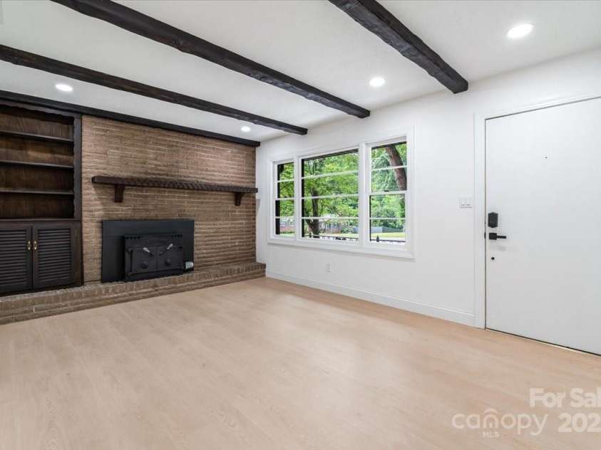 1001 Hoke Street, Kannapolis, NC 28081.  MLS# CAR4277553, YatesRealty ID 37889. Step inside as the light-filled living room showcases a vintage wood-burning fireplace, recessed lighting, & beautiful LVP flooring throughout.