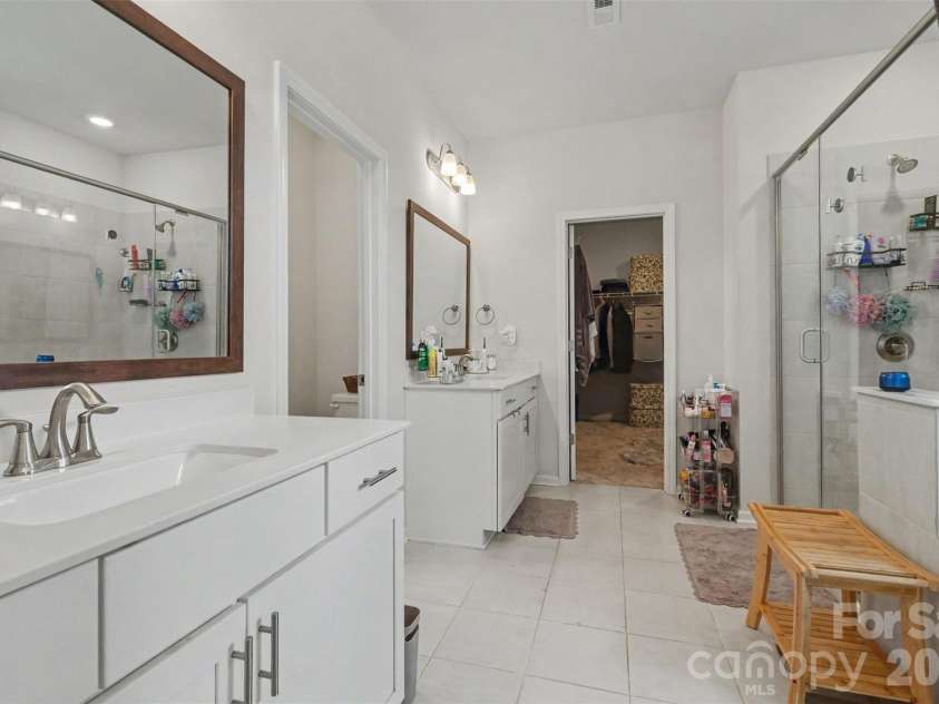 2055 Yearden Lane, Monroe, NC 28110.  MLS# CAR4397294, YatesRealty ID 37922. The primary bath features tiled flooring, separate solid surface vanities and lots of lighting...