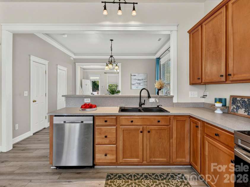 13106 Kennerly Drive, Huntersville, NC 28078.  MLS# CAR4402460, YatesRealty ID 37992. A functional layout highlights this inviting kitchen with extensive cabinetry, ample workspace, stainless steel appliances, a breakfast bar for casual seating, and direct access to the rear patio for easy indoor-ou
