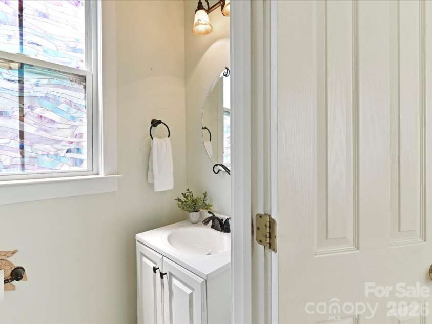 13106 Kennerly Drive, Huntersville, NC 28078.  MLS# CAR4402460, YatesRealty ID 37992. The convenient main-level powder room features a vanity with storage and a window that brings in natural light, providing added comfort for guests and everyday living.
