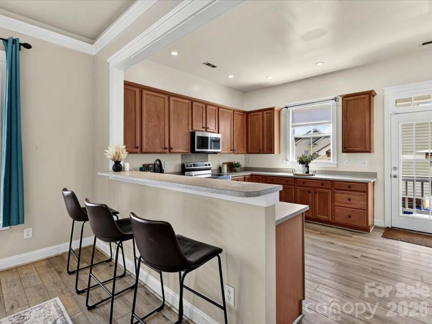 13106 Kennerly Drive, Huntersville, NC 28078.  MLS# CAR4402460, YatesRealty ID 37992. The thoughtfully designed kitchen showcases generous cabinet storage, plentiful prep space, stainless steel appliances, and a convenient breakfast bar overlooking the open-concept living spaces.