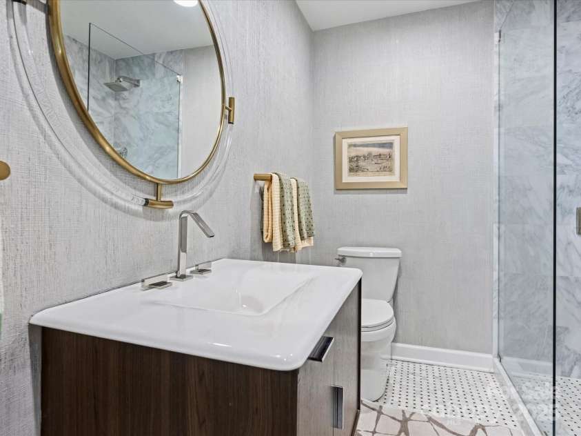 1300 Queens Road, Charlotte, NC 28207.  MLS# CAR4283635, YatesRealty ID 3800. Hall Bathroom with Custom Floating Vanity, Marble Floors, Marble Shower with Glass