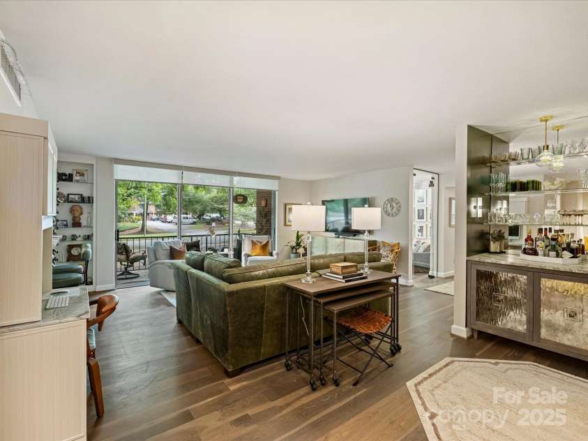 1300 Queens Road, Charlotte, NC 28207.  MLS# CAR4283635, YatesRealty ID 3800. Living Room with Triple Panel Sliding Doors, Built-In Bookcases, Custom Desk and Bar
