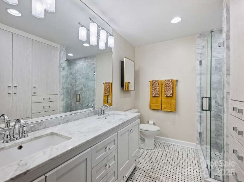 1300 Queens Road, Charlotte, NC 28207.  MLS# CAR4283635, YatesRealty ID 3800. Primary Bathroom with Custom Dual Vanity with Marble Counters, Marble Floors, Marble Shower, Seamless Glass Shower Door, Two Medicine Cabinets