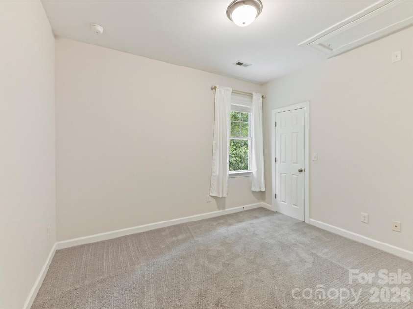 8707 Lake Pines Drive, Cornelius, NC 28031.  MLS# CAR4402781, YatesRealty ID 38115. Comfortable secondary bedroom features plush carpeting, a spacious closet, and flexible space ideal for family, guests, or a home office.