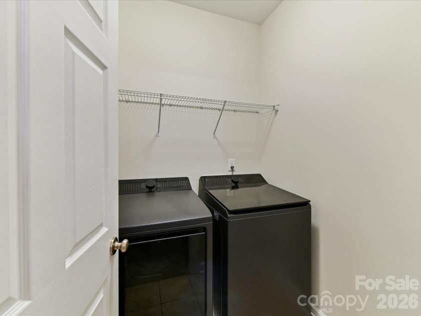 8707 Lake Pines Drive, Cornelius, NC 28031.  MLS# CAR4402781, YatesRealty ID 38115. Convenient upper-level laundry room with built-in shelving provides added storage and everyday functionality.