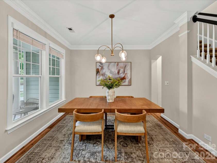 8707 Lake Pines Drive, Cornelius, NC 28031.  MLS# CAR4402781, YatesRealty ID 38115. Elegant dining room features abundant natural light, crown molding, and a spacious layout, creating the perfect setting for everyday meals and memorable gatherings.