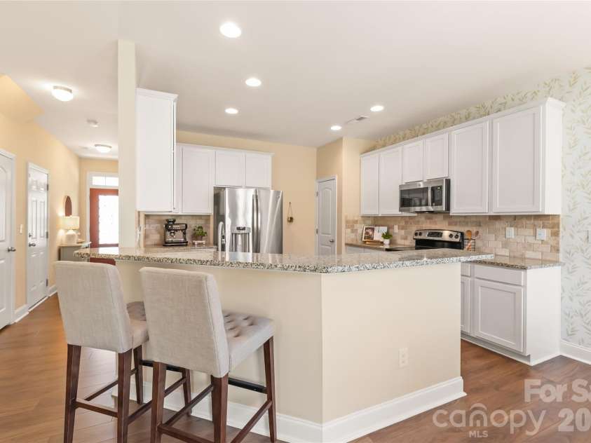 4303 Hampstead Heath Drive, Waxhaw, NC 28173.  MLS# CAR4402437, YatesRealty ID 38129. This beautifully updated chef’s kitchen combines style and function with gleaming granite countertops, crisp white cabinetry, and a modern tile backsplash.