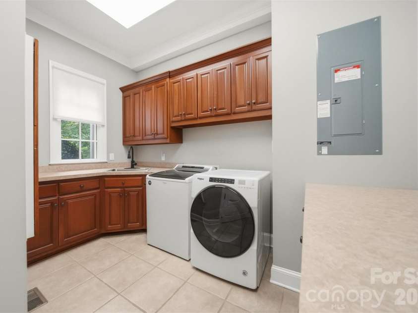 3745 Pinecrest Drive, Hickory, NC 28601.  MLS# CAR4403164, YatesRealty ID 38139. Laundry Room on main level, tile flooring, sink, built in cabinets, folding table, attached iron board....so much to talk about.