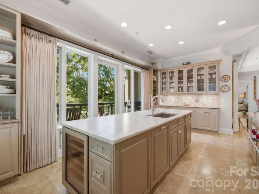 229 Church Street, Charlotte, NC 28202.  MLS# CAR4381312, YatesRealty ID 3818. Beautifully designed chef’s kitchen featuring custom cabinetry, natural stone countertops, premium appliances, and an oversized island perfect for entertaining. Expansive windows fill the space with natural light and over