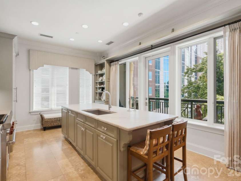 229 Church Street, Charlotte, NC 28202.  MLS# CAR4381312, YatesRealty ID 3818. Designer kitchen with expansive island seating, custom cabinetry, premium appliances, and large windows that bring in beautiful city and treetop views.