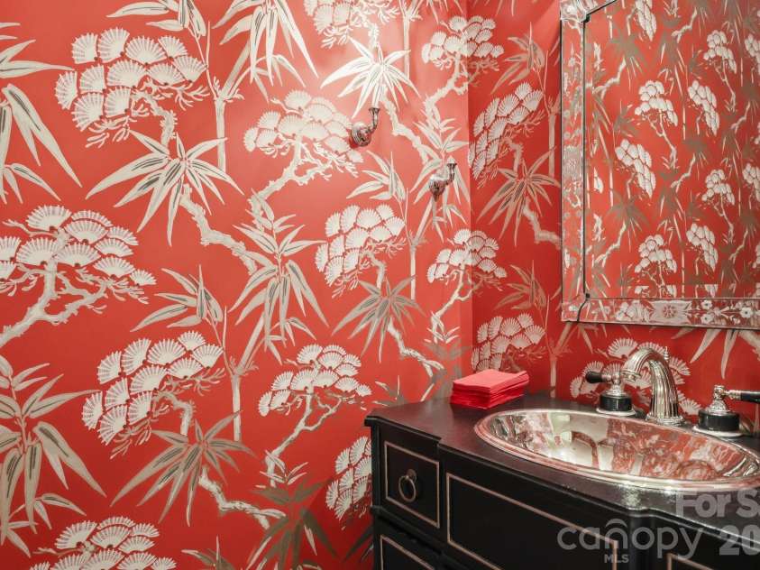 229 Church Street, Charlotte, NC 28202.  MLS# CAR4381312, YatesRealty ID 3818. Designer powder room featuring bold wallpaper, statement finishes, and curated details that add warmth, character, and sophistication.